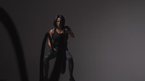 Studio-Shot-Of-Mature-Woman-Wearing-Gym-Fitness-Clothing-Doing-Cardio-Exercise-With-Battle-Ropes-2